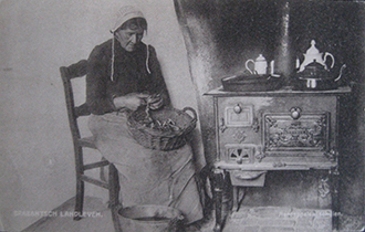 אשת הצלם מקלפת תפוחי אדמה ליד התנור. נישייה ואן דרונן, הולנד, 1910